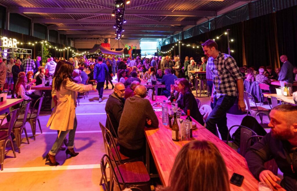bedrijfshal- lange tafels- bbq- shared diner- jubileumfeest